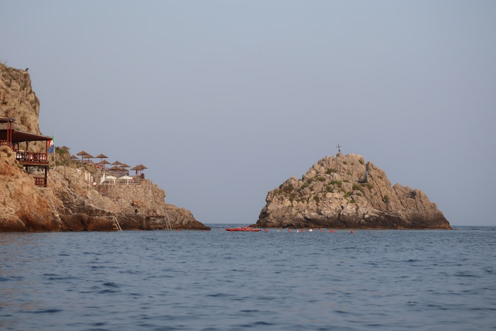 a boat is in the water near some rocks