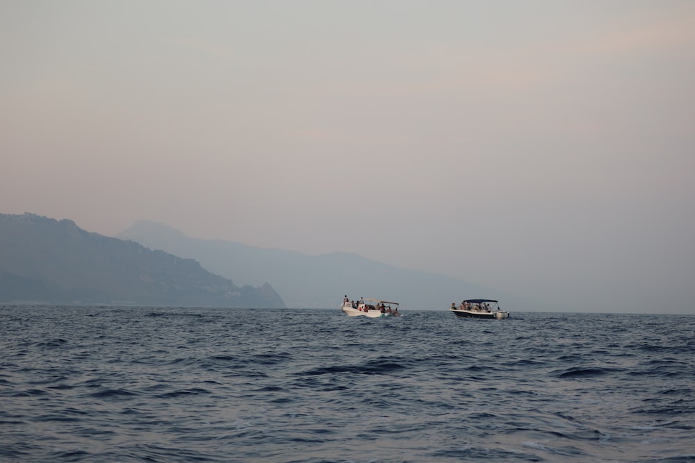 a couple of boats floating on top of a large body of water