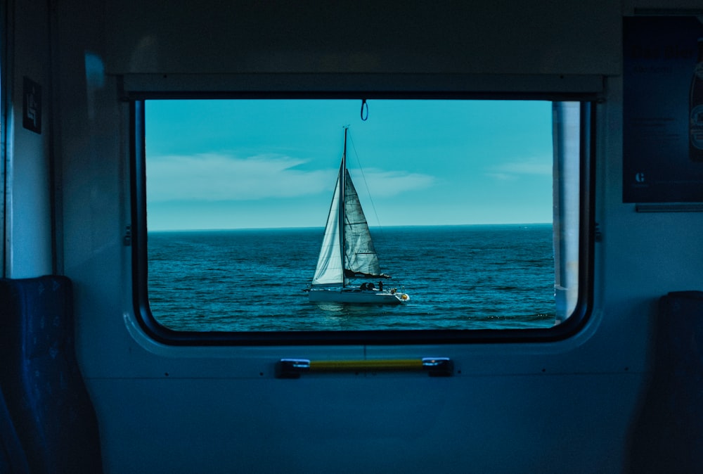 a sailboat sailing in the ocean through a window