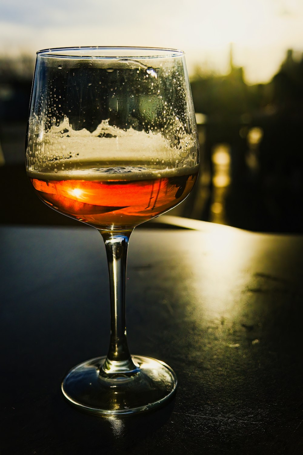 um close up de uma taça de vinho sobre uma mesa