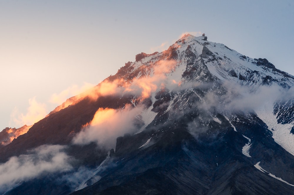 una montaña muy alta con algunas nubes en la parte superior