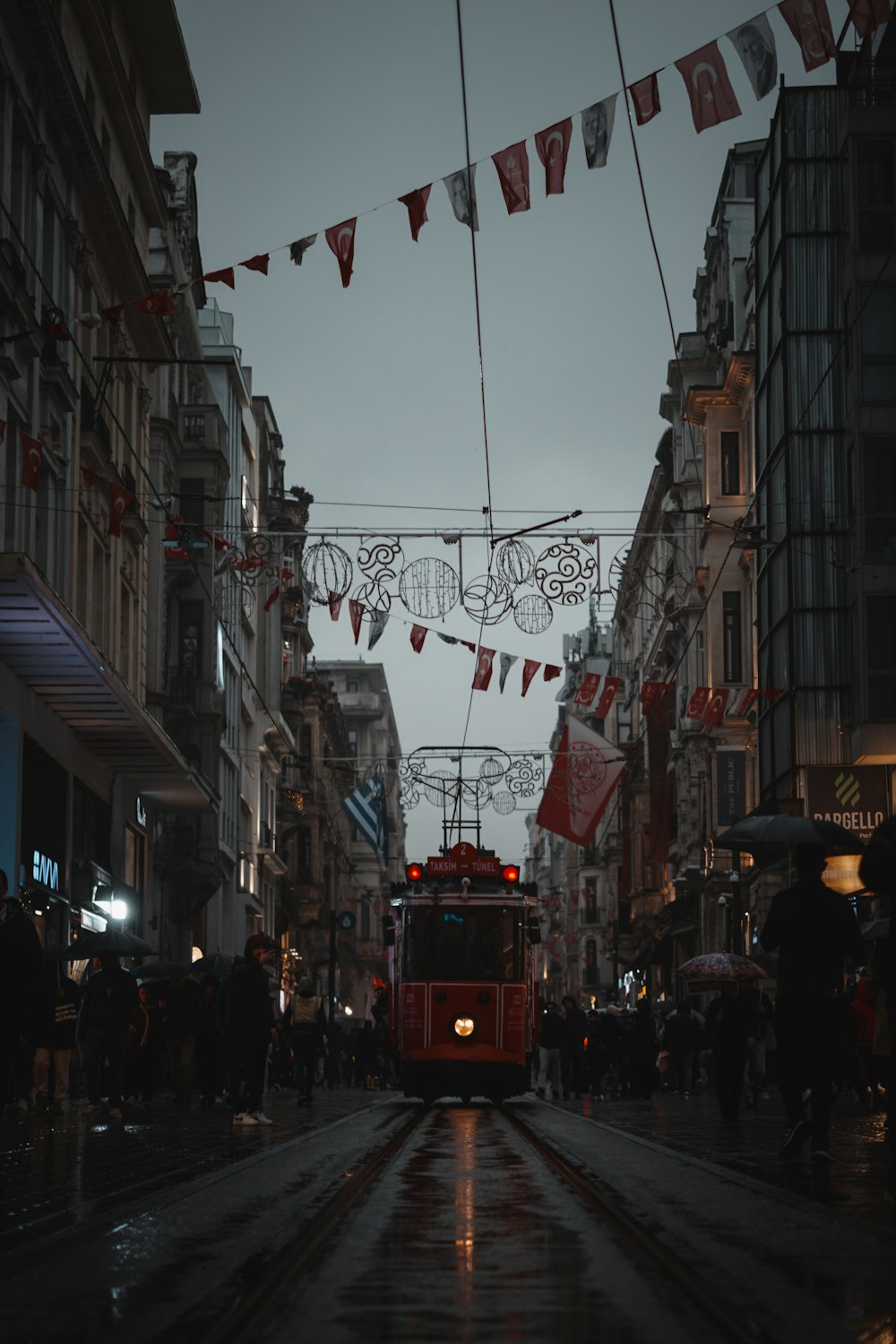 a red trolley on a city street at night