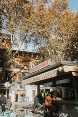 a group of people sitting at a table in front of a building