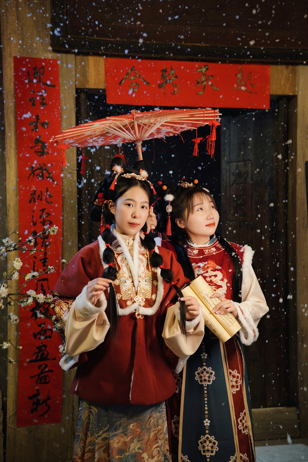 a couple of women standing next to each other under an umbrella