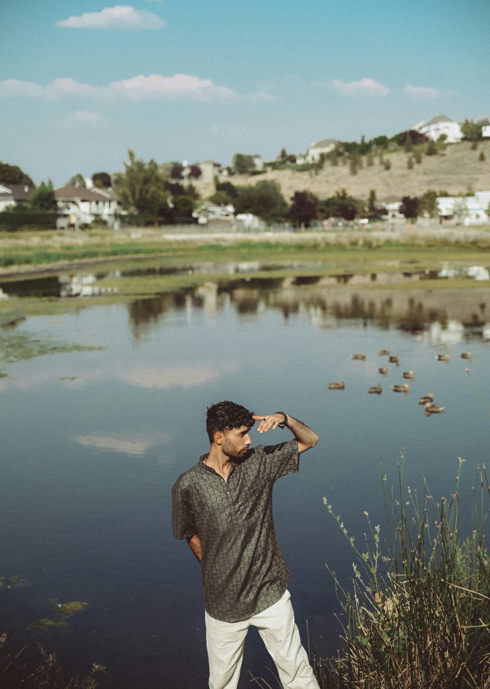 a man standing next to a body of water