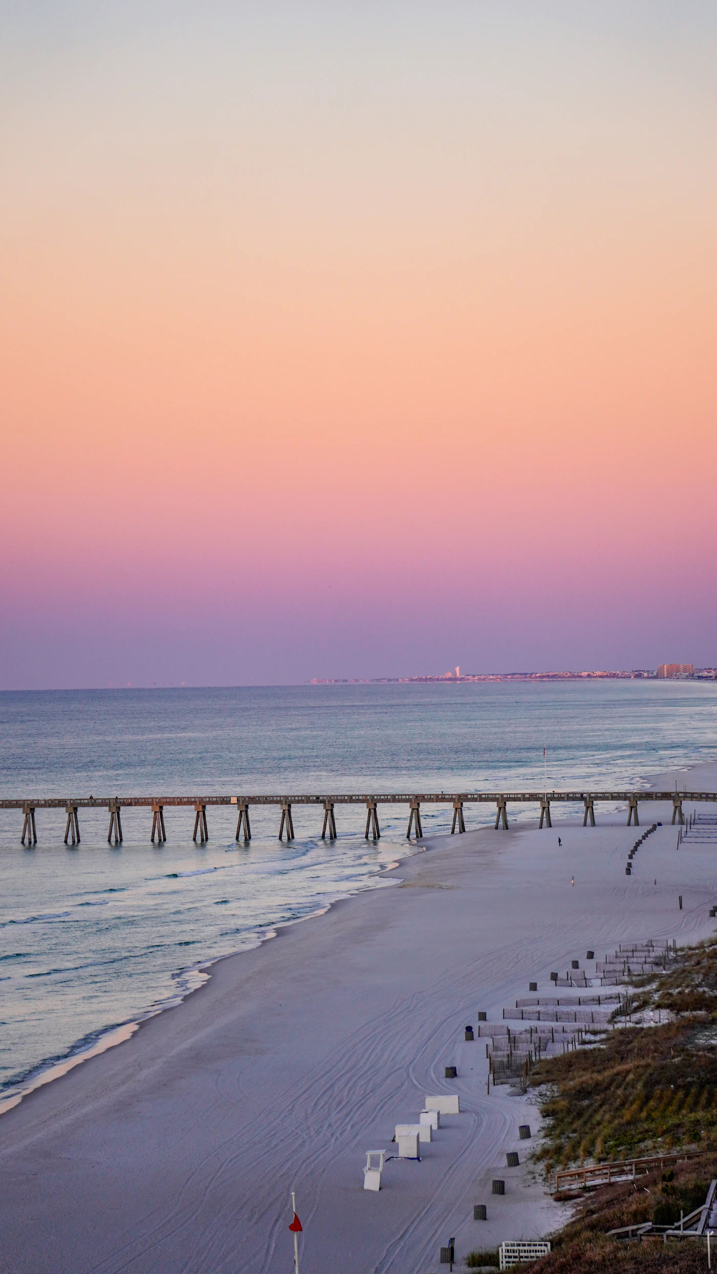 A long pier reaching out into the Gulf at dusk