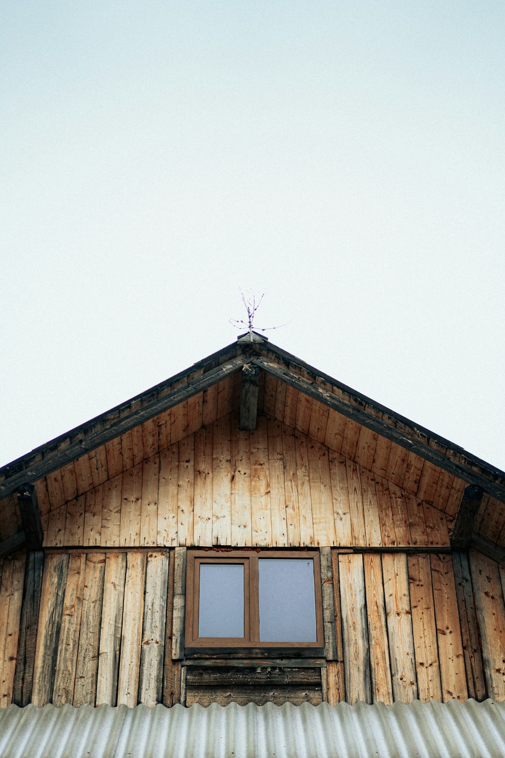 a wooden building with a metal roof and a window