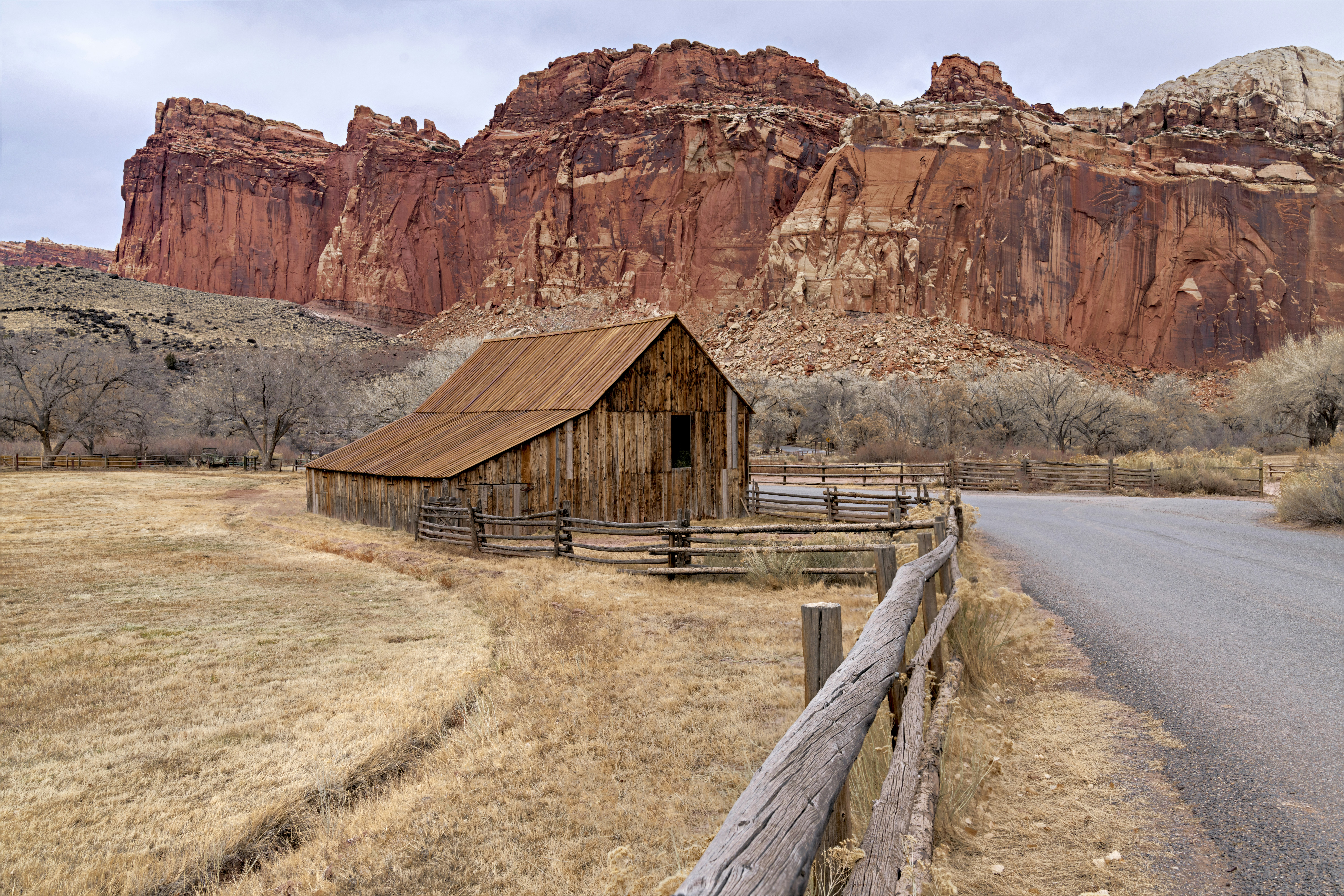an old barn sits on the side of the road