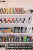 a shelf filled with lots of different types of pens and pencils