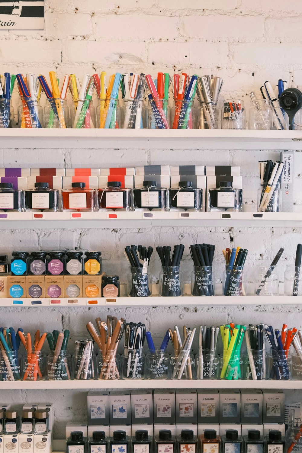 a shelf filled with lots of different types of pens and pencils