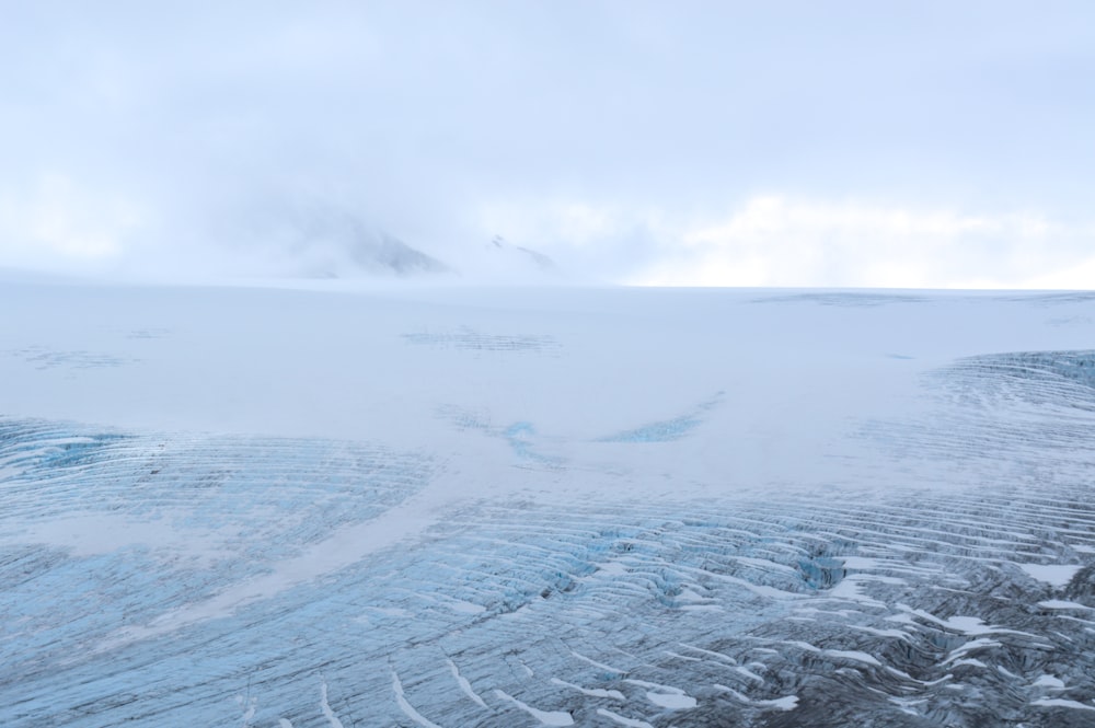 a snowy landscape with a mountain in the distance