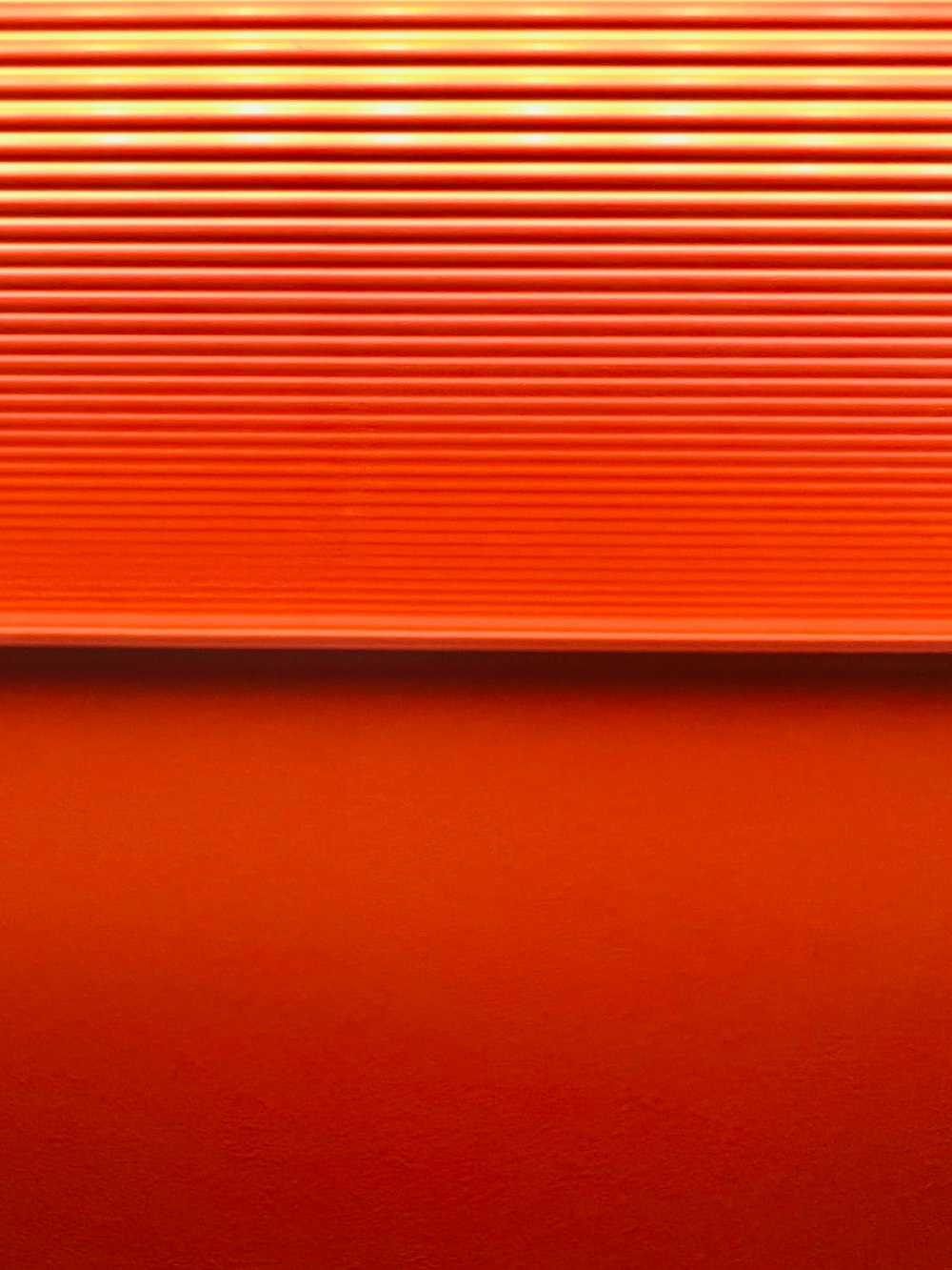 a close up of an orange surface with vertical lines