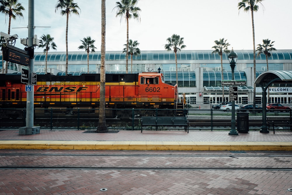 a train on a train track near palm trees