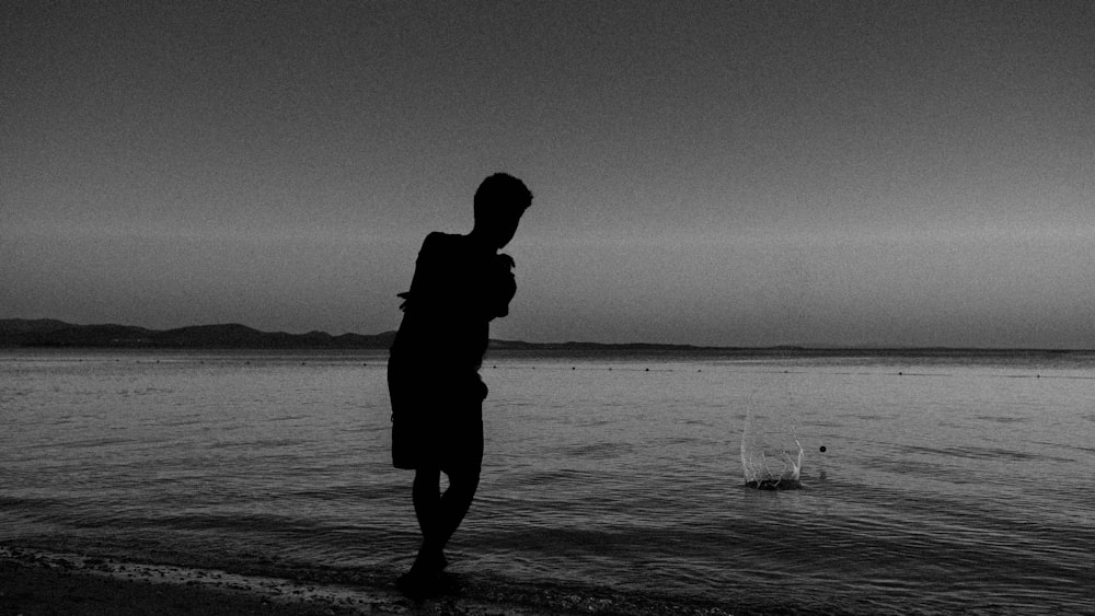 a person standing on a beach next to the ocean