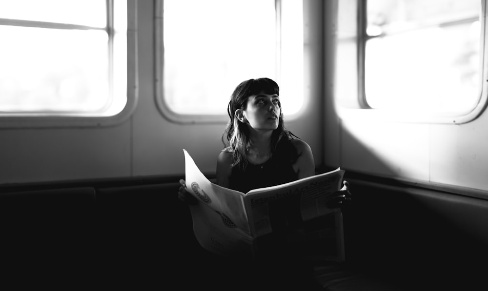 a woman reading a book while sitting on an airplane