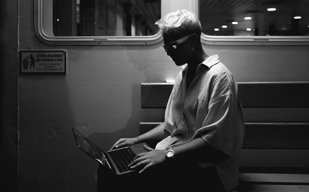 a person sitting on a bench with a laptop