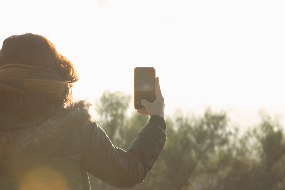 une personne qui prend une photo avec un téléphone cellulaire ;