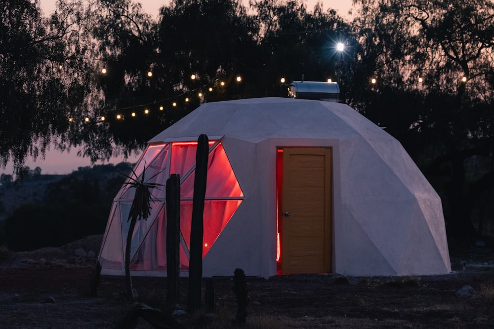 un piccolo edificio bianco con una porta rossa