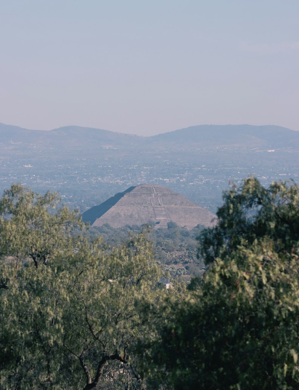 a view of a mountain range with trees in the foreground