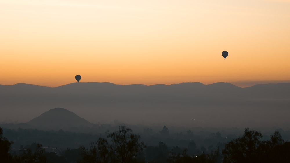 Un par de globos aerostáticos volando en el cielo