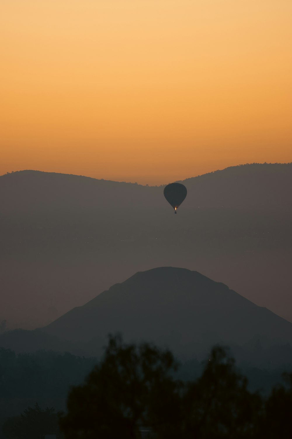 a hot air balloon flying over a mountain range