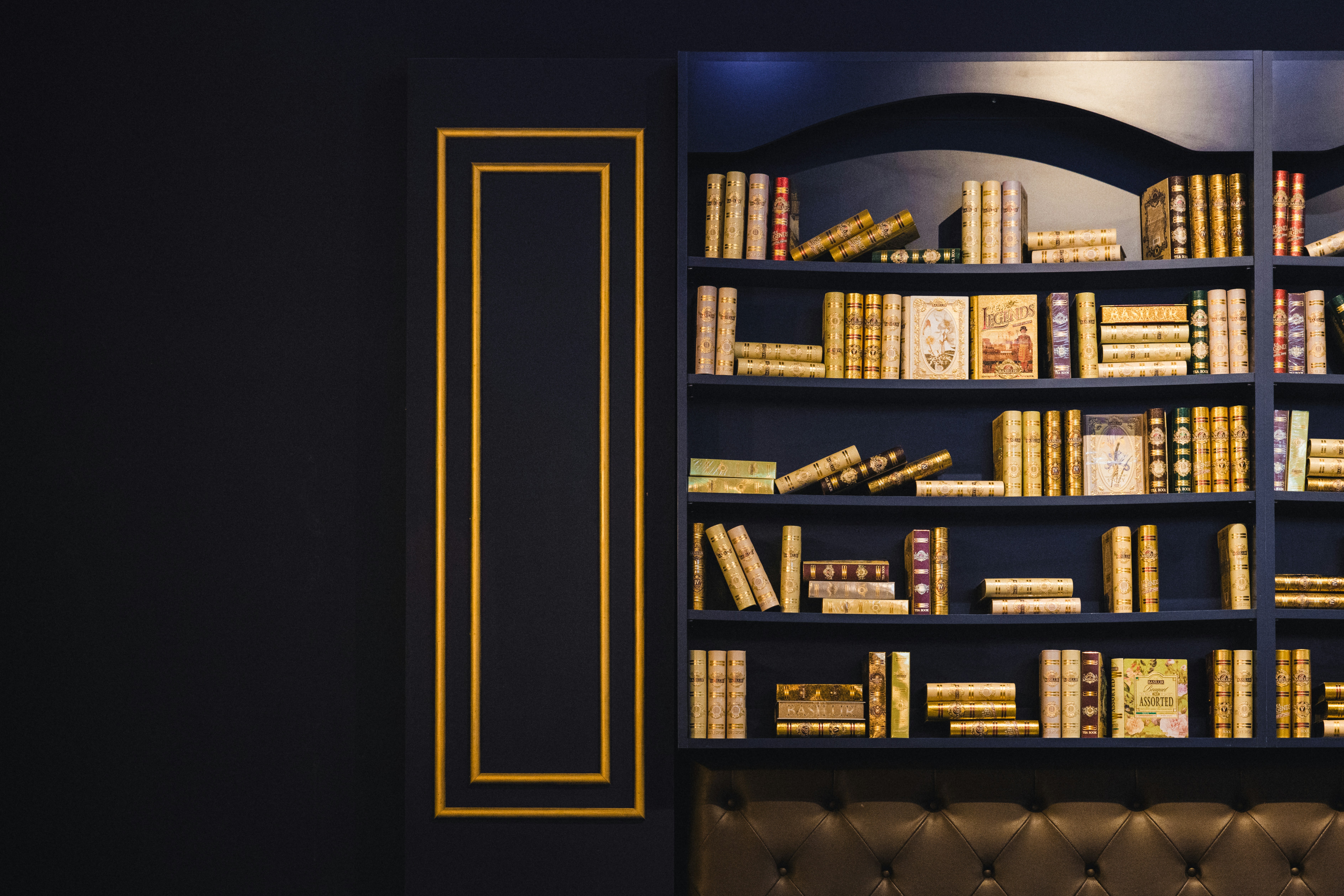 a bookshelf filled with lots of books in a room
