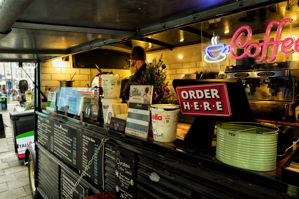 a coffee shop with a neon sign above the counter