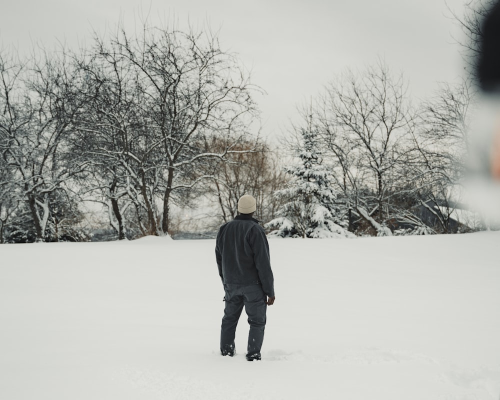 a man standing in the middle of a snow covered field