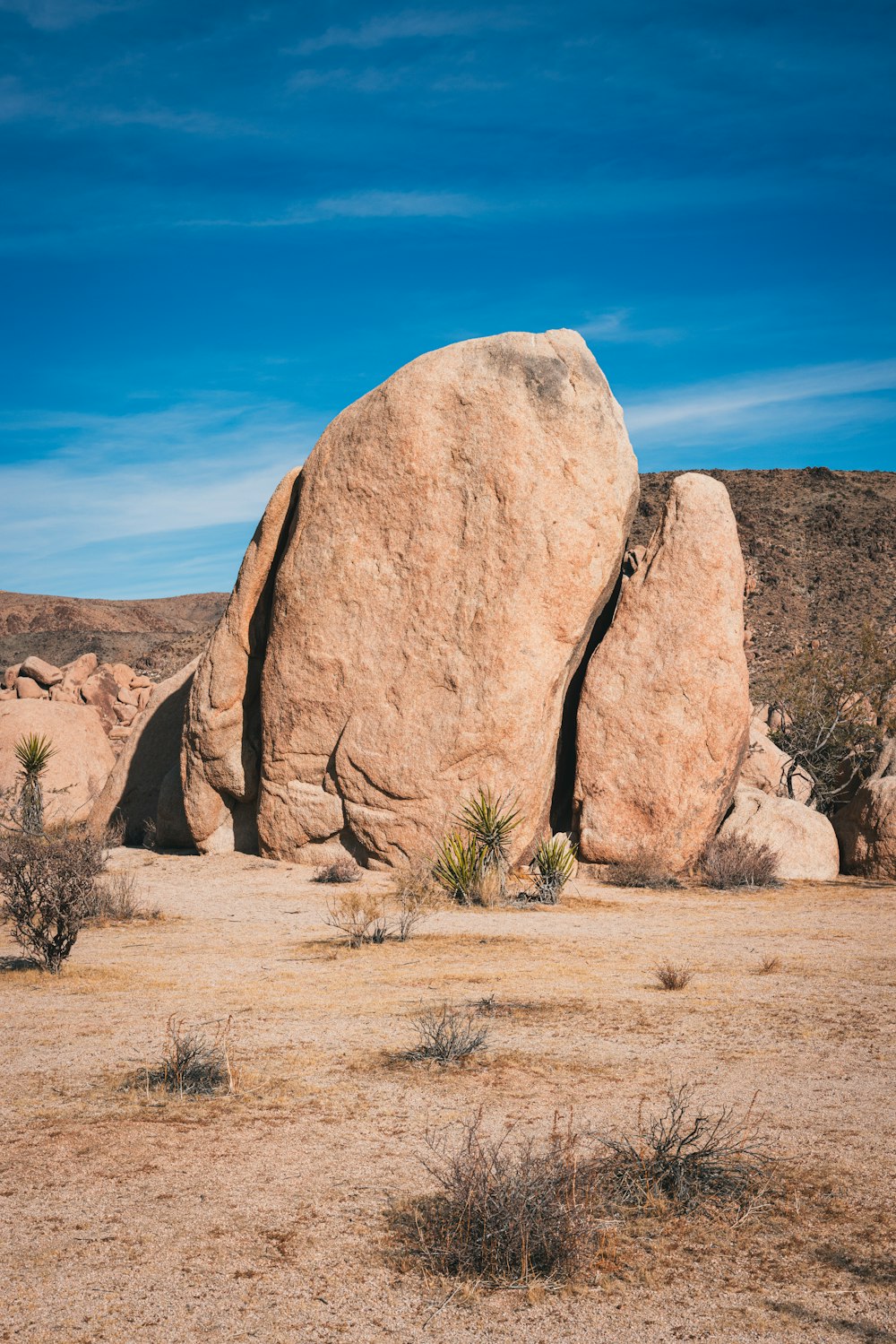 a large rock in the middle of a desert