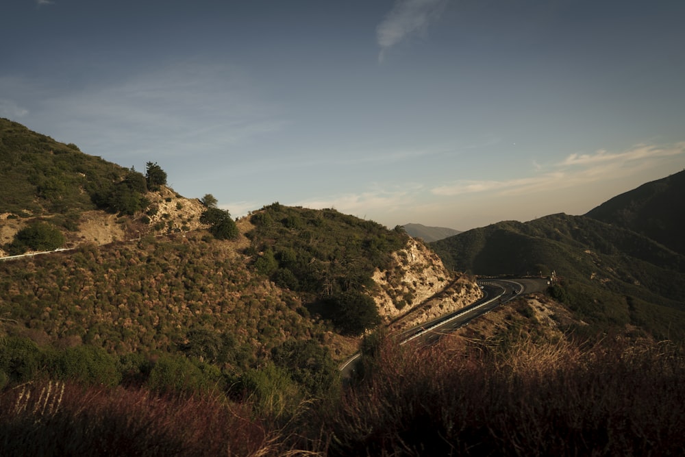 a scenic view of a winding road in the mountains