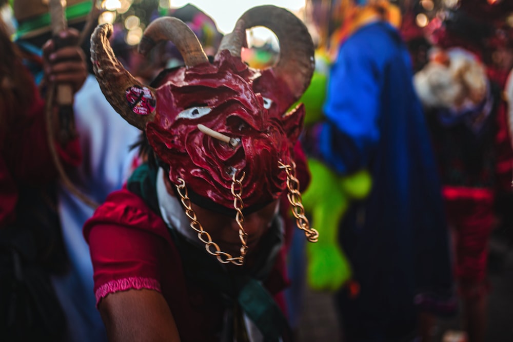 a person wearing a mask with horns and chains