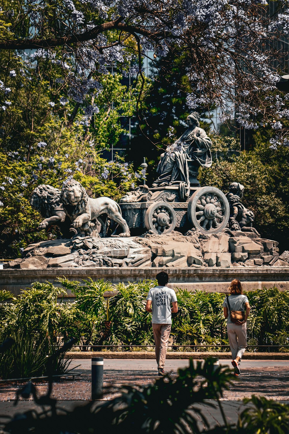 a couple of people that are walking by a statue