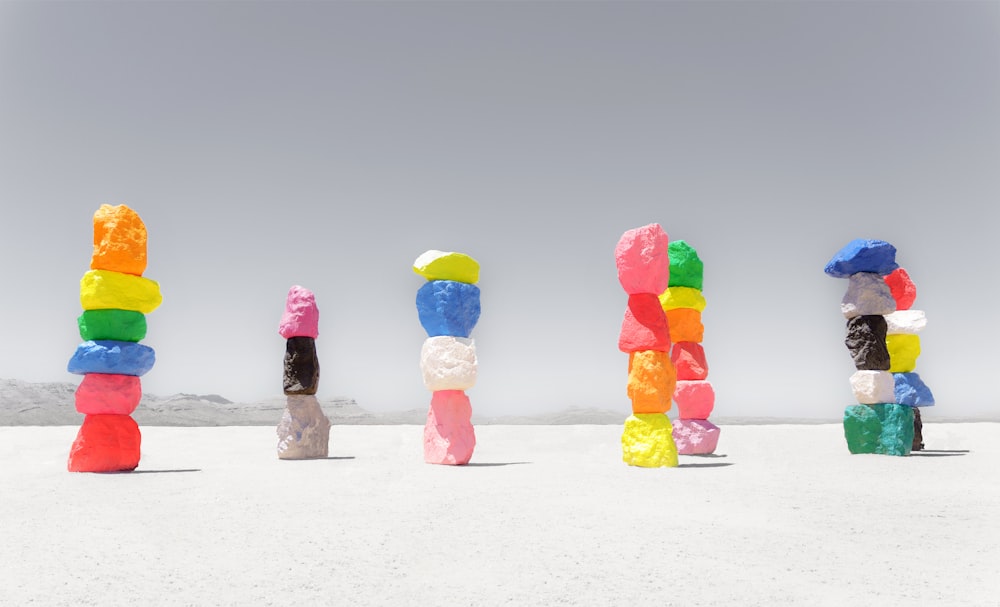 a group of colorful rocks sitting on top of a sandy beach