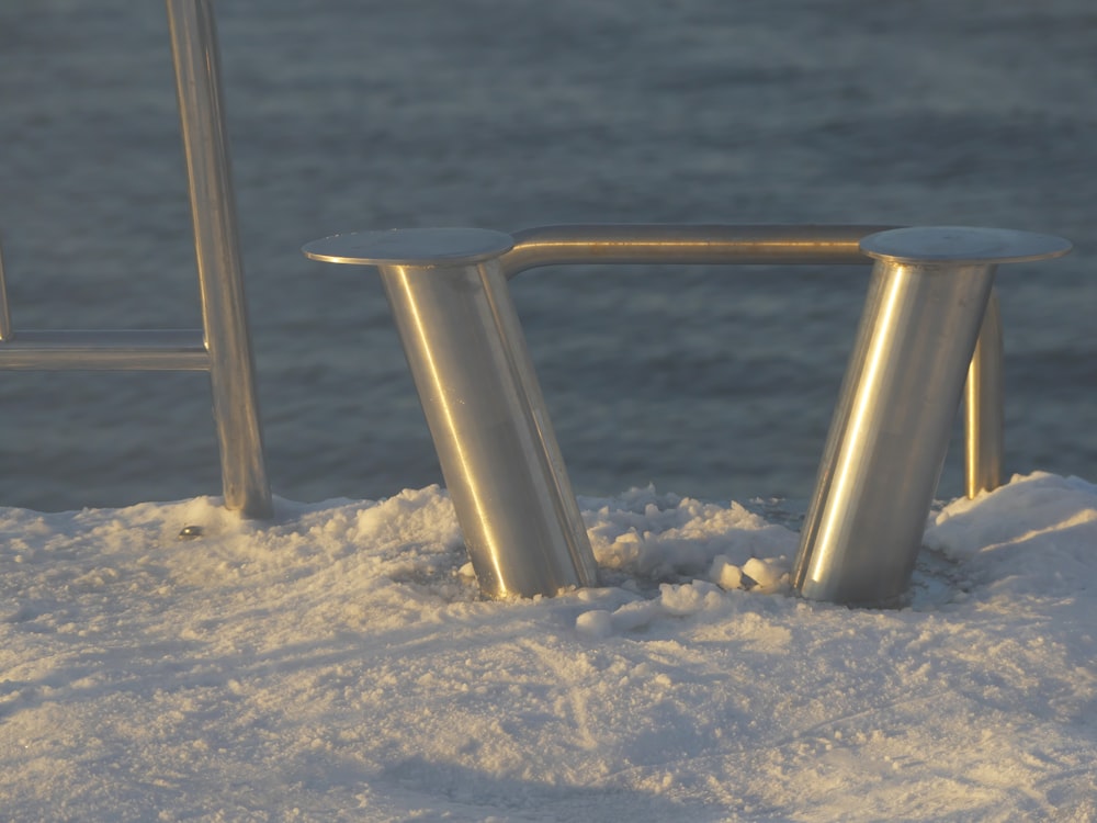 a bench sitting in the snow next to the ocean
