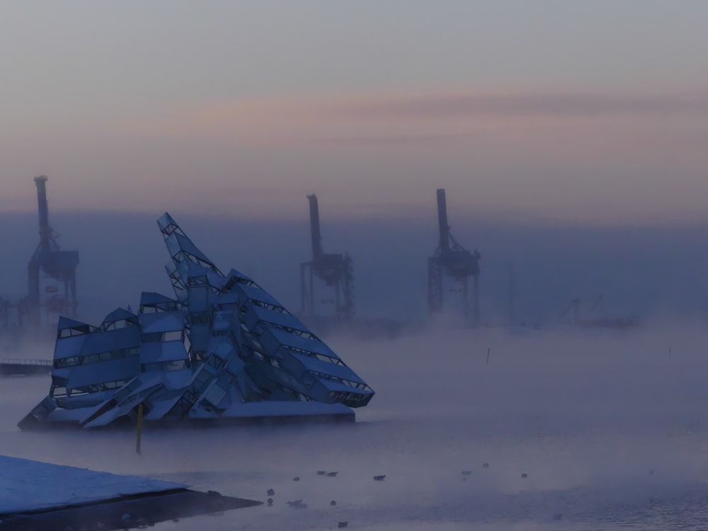 a large metal object sitting in the middle of a foggy field
