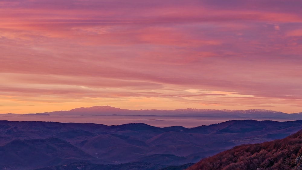 uma vista de uma cordilheira ao pôr do sol