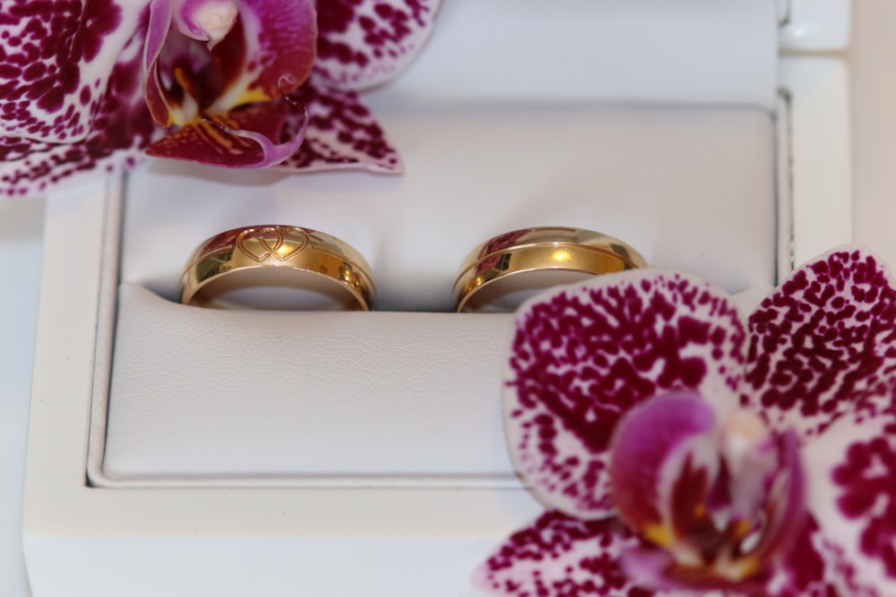 two wedding rings sitting on top of a white box