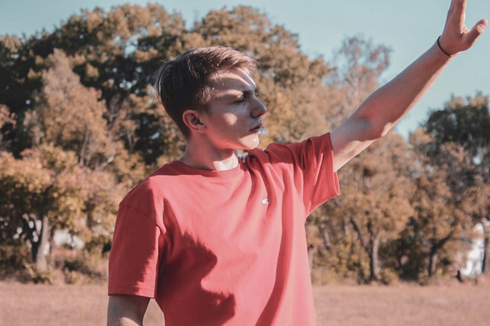 a young man is throwing a frisbee in a field