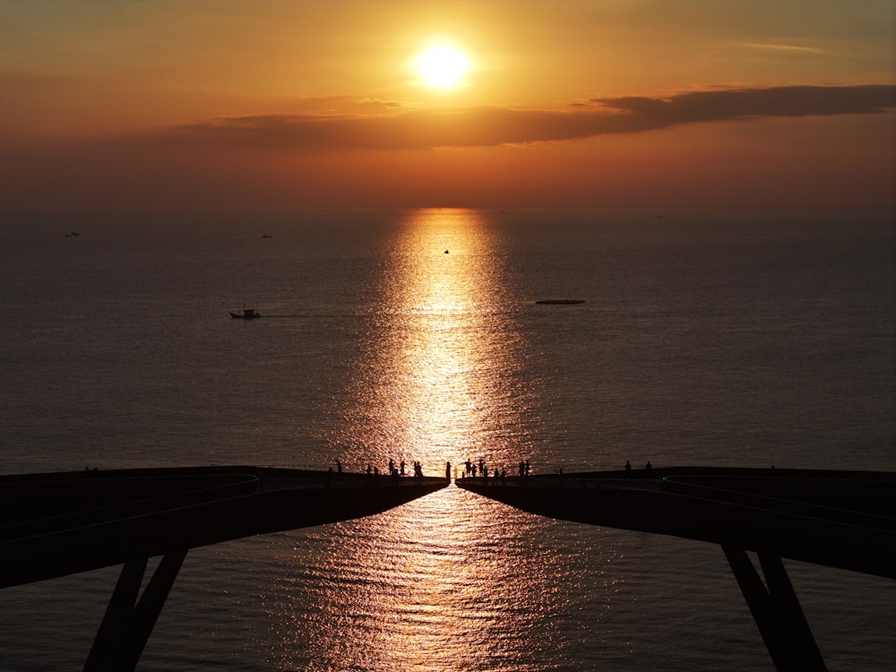 a large body of water with a sunset in the background