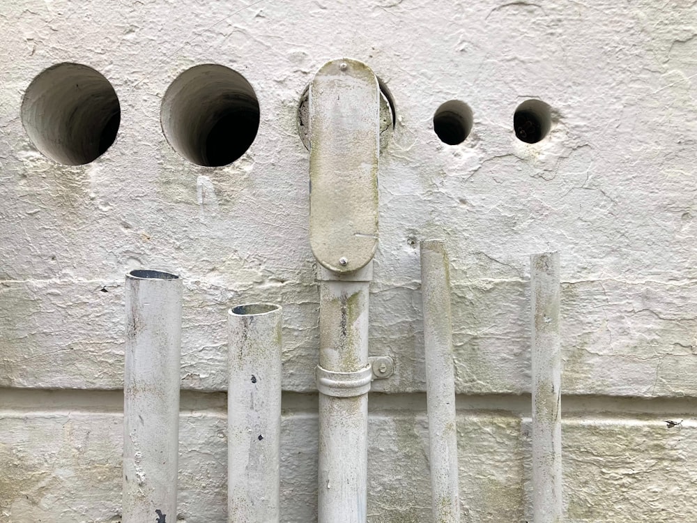 a group of pipes mounted to the side of a building