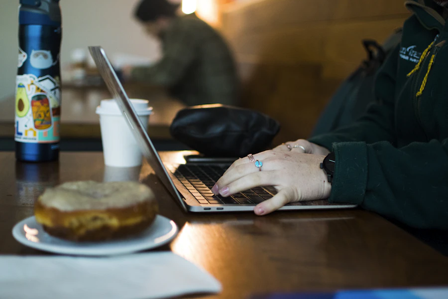 Portátil y café sobre una mesa de madera