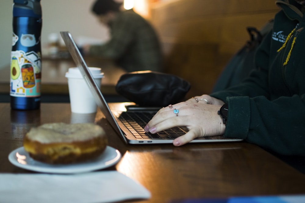 a person using a laptop on a wooden table