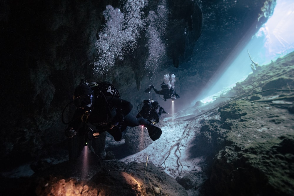 a group of people in scuba gear in a cave