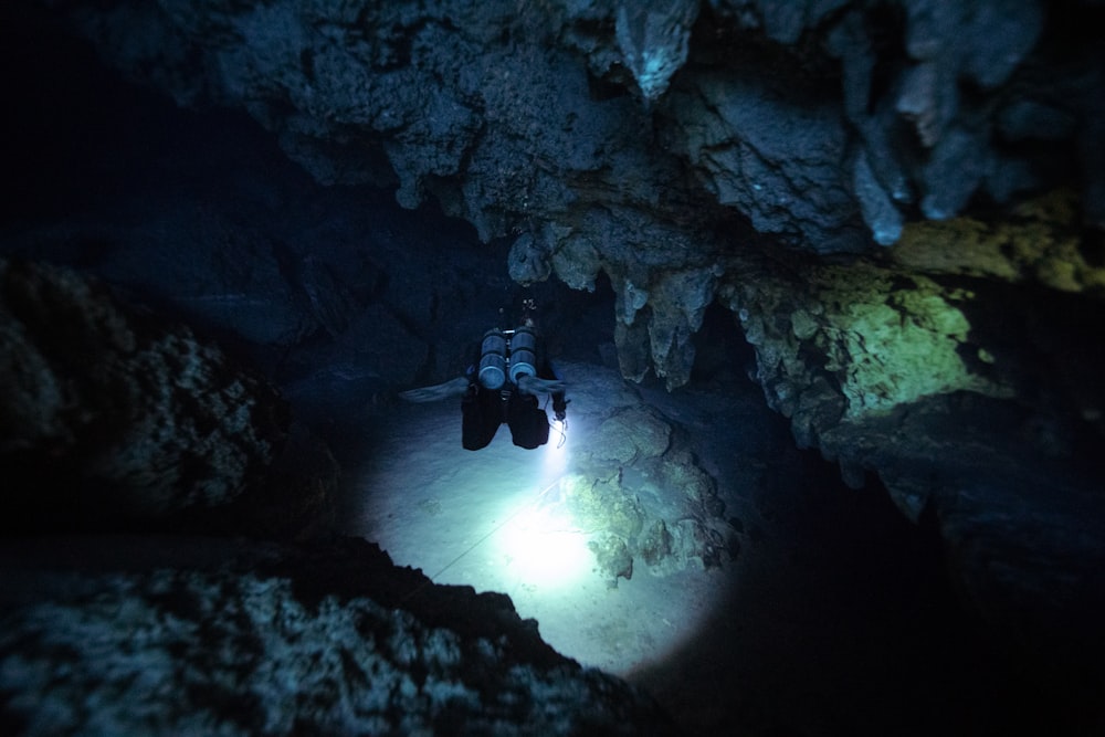 a person in a cave with a flashlight