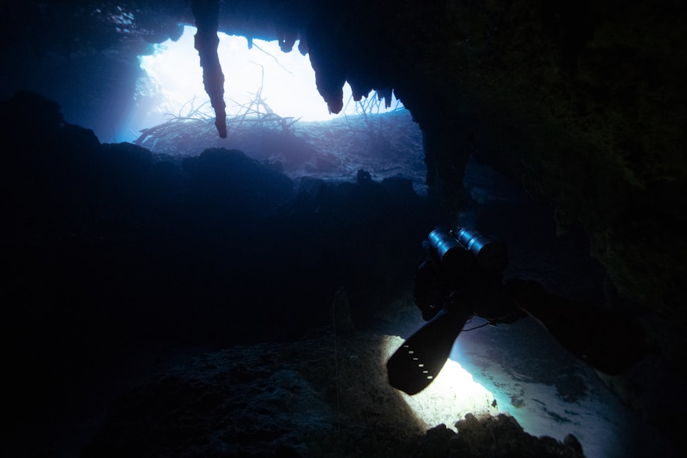 a person in a cave with a flashlight in their hand