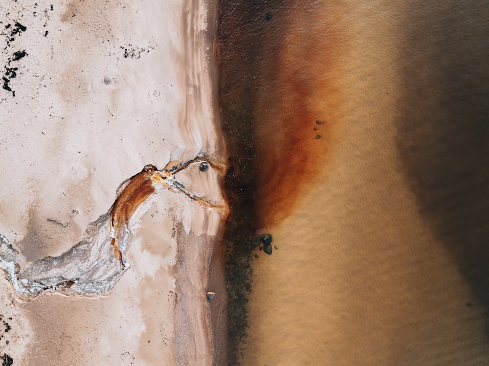an aerial view of a sandy beach with rust on it