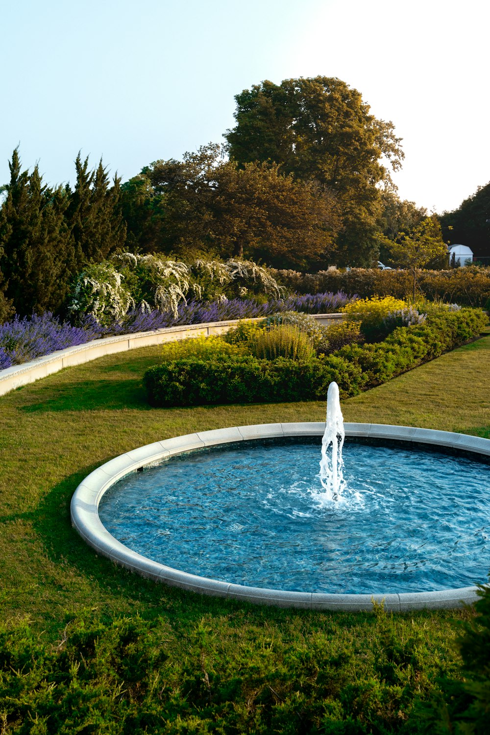 a water fountain in the middle of a garden