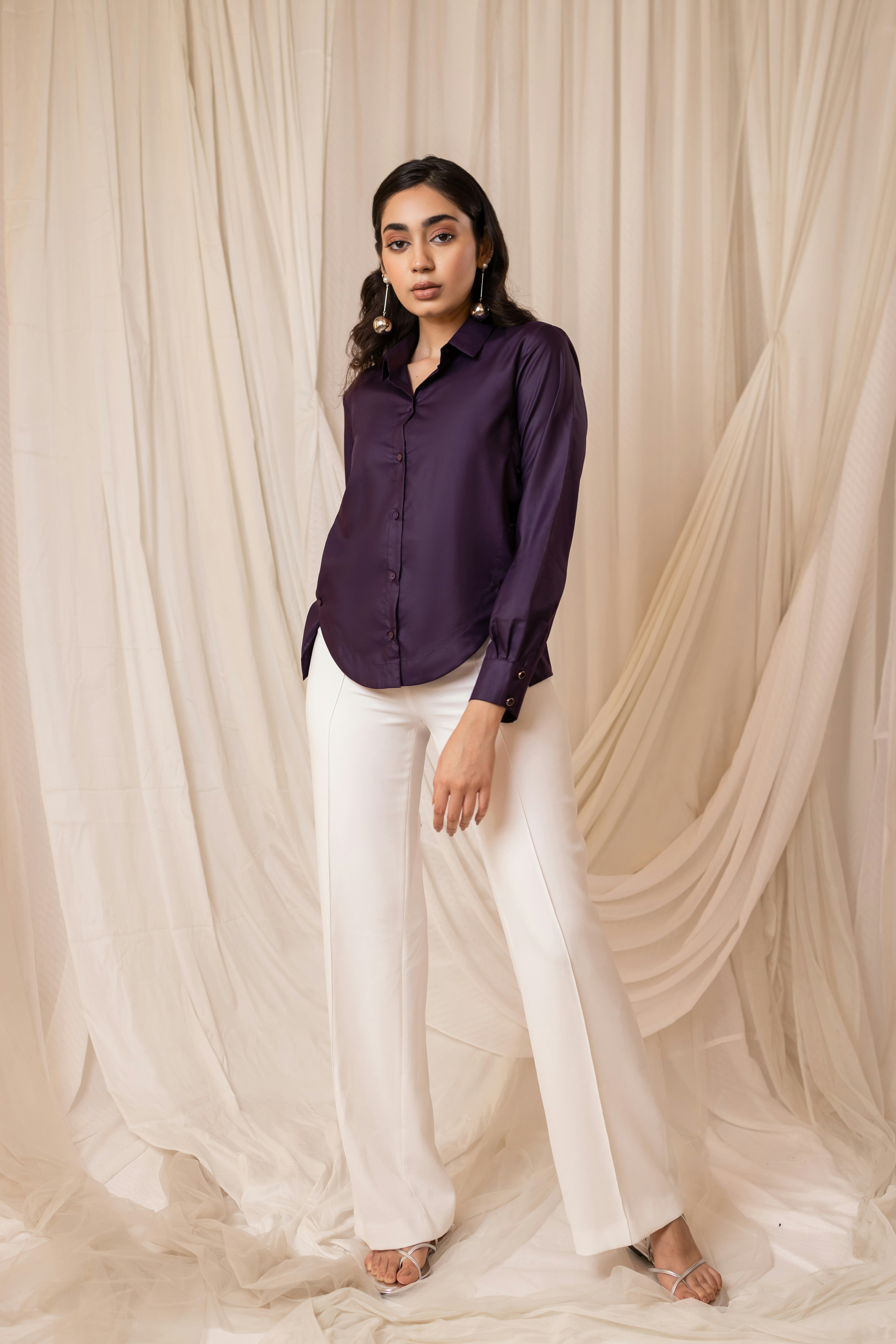 Woman in dark purple shirt and white pants