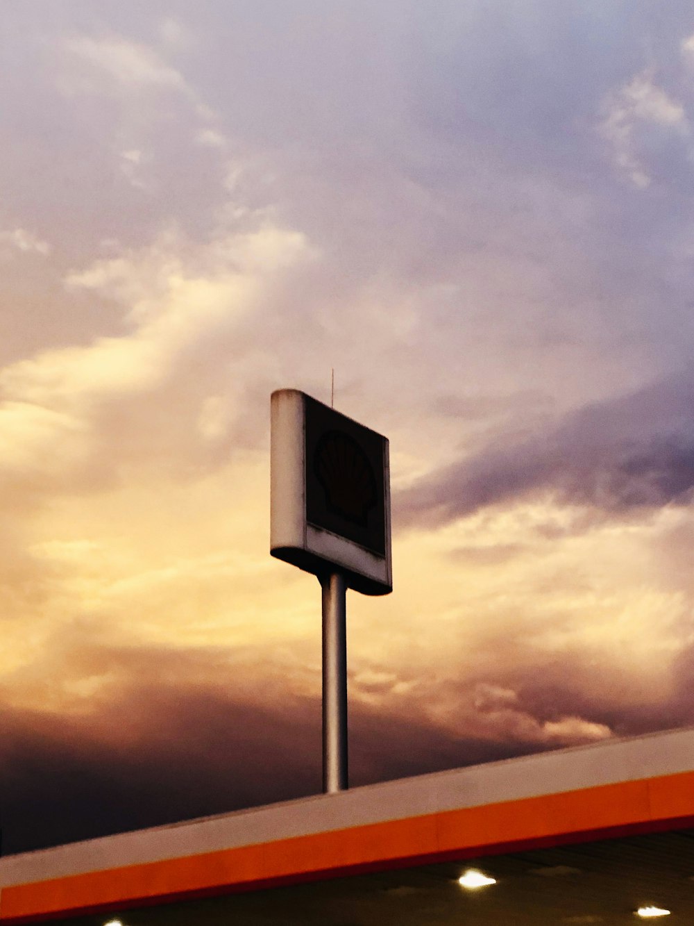 a street sign on a pole in front of a cloudy sky