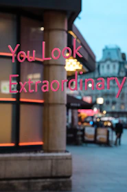a blurry photo of a building with a sign that says you look extraordinary